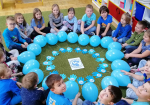 Dzieci ułożyły z niebieskich balonówi i szablonów dłoni kształt Kuli Ziemskiej